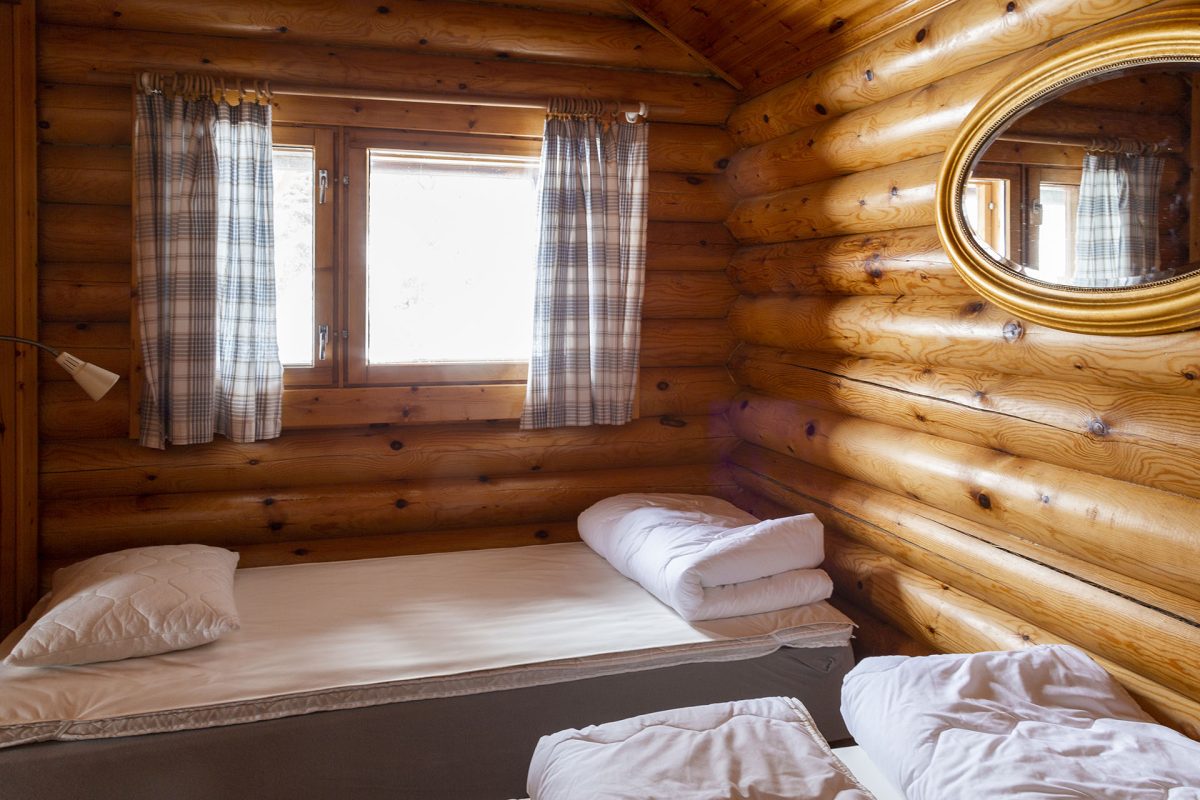 Спальня с двумя кроватями, окном, на стене – зеркало в форме эллипса.